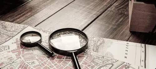 Magnifying glass on investigation maps